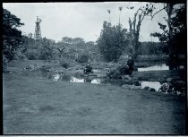 Two priests and a boy near stream and signal tower, Moanalua Gardens, Oahu.